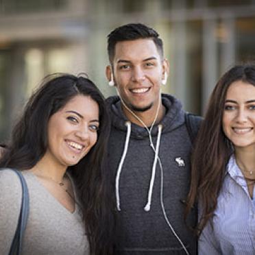 Three international students enjoy a moment outside on campus