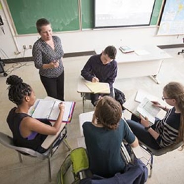 Students sit in a circle with their professor to discuss the French language. 