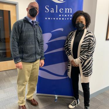 President Keenan and former Boston Mayor Kim Janey stand next to a blue Salem State banner. They are both wearing masks.
