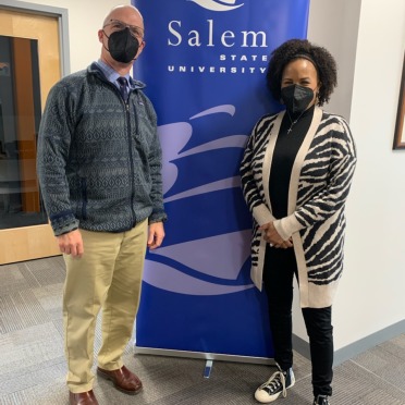 President Keenan and former Boston Mayor Kim Janey stand next to a blue Salem State banner. They are both wearing masks.