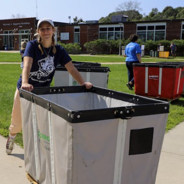A student move-in volunteer with a rolling cart