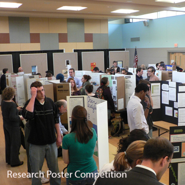 Poster board projects stand up on tables, a room full of people look at the projects.