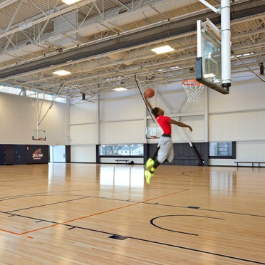 A student dunking a basketball on the rec court