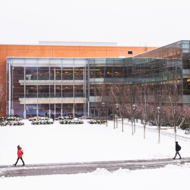 Students walk in front of the Berry Library at Salem State on a snowy day.