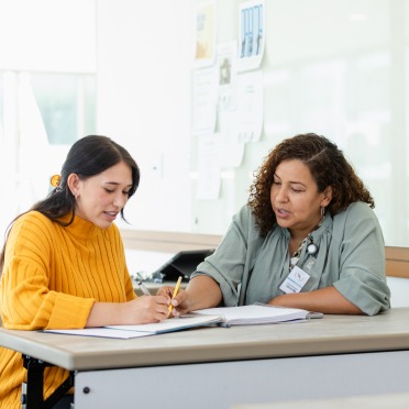 A student an staff member meeting at a desk