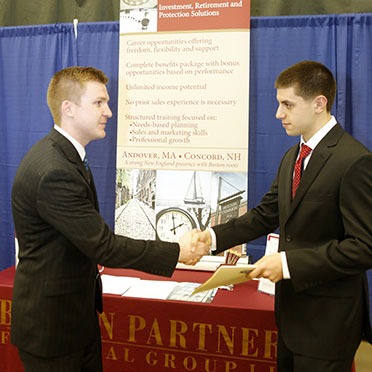 Career services career fair image featuring finance recruiter and male student