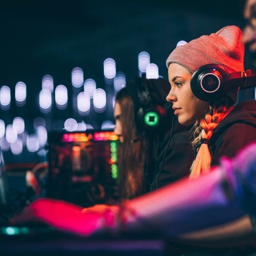 Three players at computers with headphones