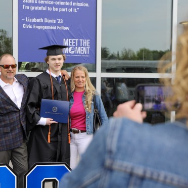 A graduate and his family pose together