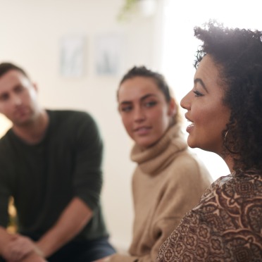 Group of three adult students talking together