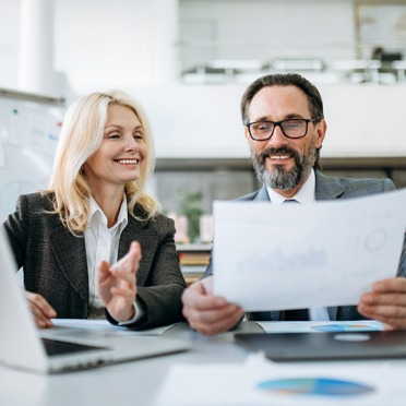 Two people sitting in an office looking at paperwork