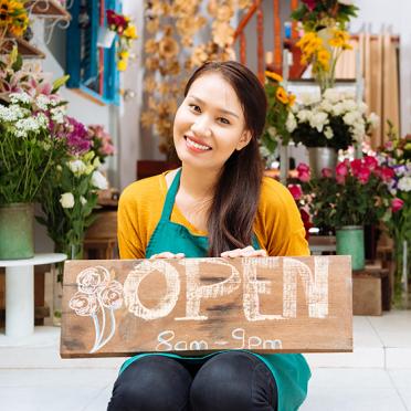 Smiling woman with open sign