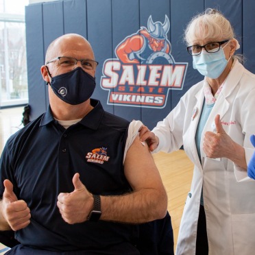 President Keenan and a nurse give a thumbs up after a vaccination