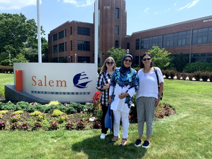 Saba Mahboubkhalajani and CIE staff in front of Salem State sign