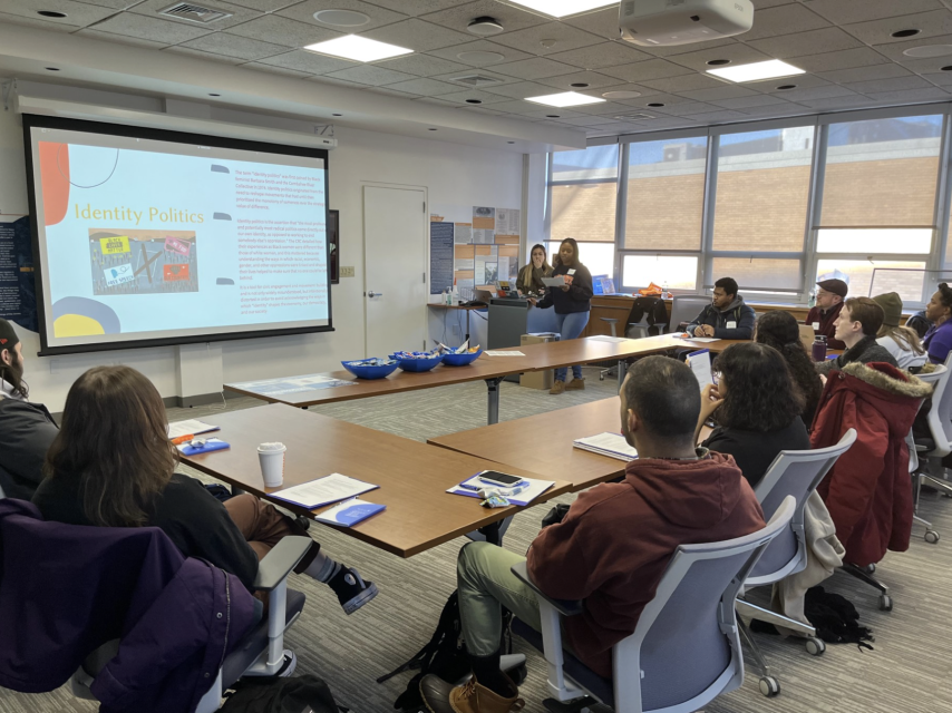 Students at the Running for Office session sit in a classroom and look at a projector screen.