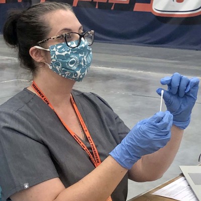 A team member from counseling and health demonstrates the COVID swab test.