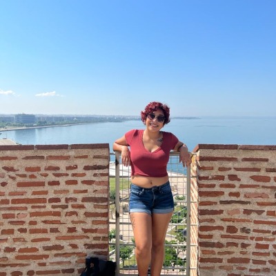 Damaris Lopez stands by a brick wall overlooking the ocean.