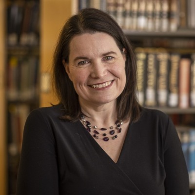 Elizabeth McKeigue pictured in front of stacks of books.