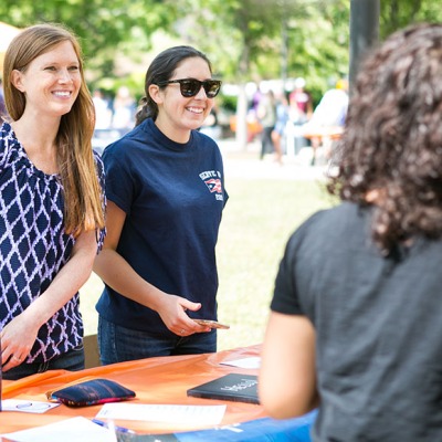 Two student leaders greet prospective members at the student organizations fair