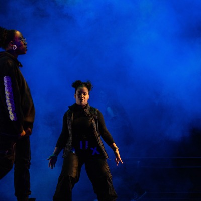 Two hip hop dancers on a blue smoky stage