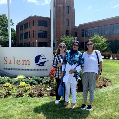 Saba Mahboubkhalajani and CIE staff in front of Salem State sign
