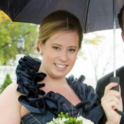 Julie Palmedo standing under an umbrella in a black dress