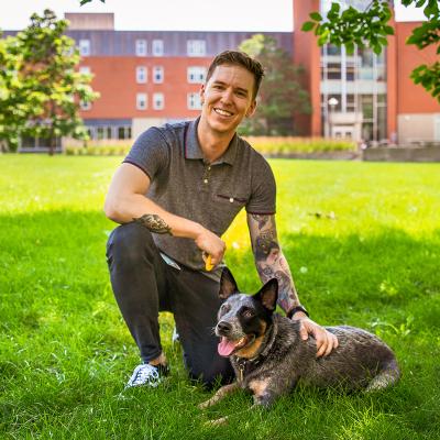 Nick DiFranco poses with Otto the campus community dog