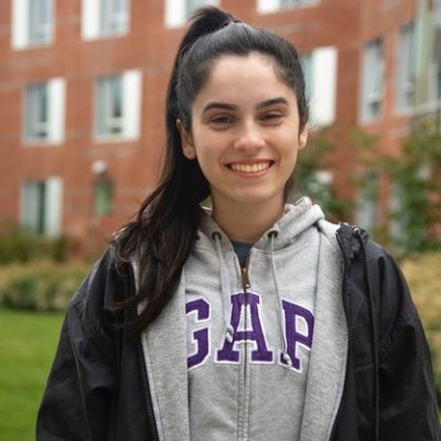 Natasha Farina smiles outside a building on campus