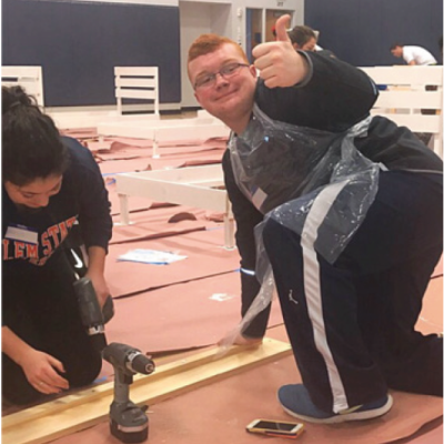A student in the inclusive scholars program works on a volunteer building project.