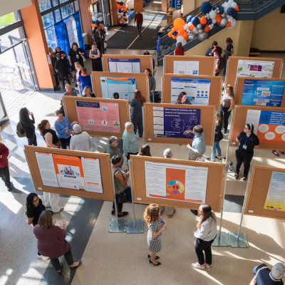 People walking around posters. 