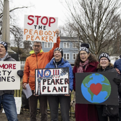 Depicted: a group of people stand outside protesting. They hold signs that say "No more dirty pipelines", "Stop the Peabody Peaker".
