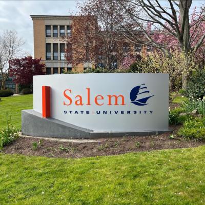 Spring day in front of the Salem State University sign in front of the Sullivan building