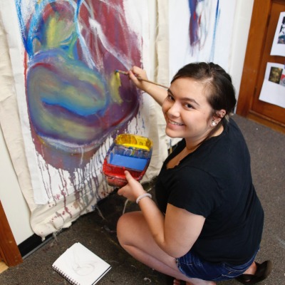 Salem State senior Emily Kwong works on a large-scale art piece.