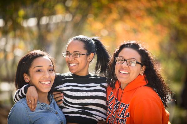Three female students hangout in the campus quad