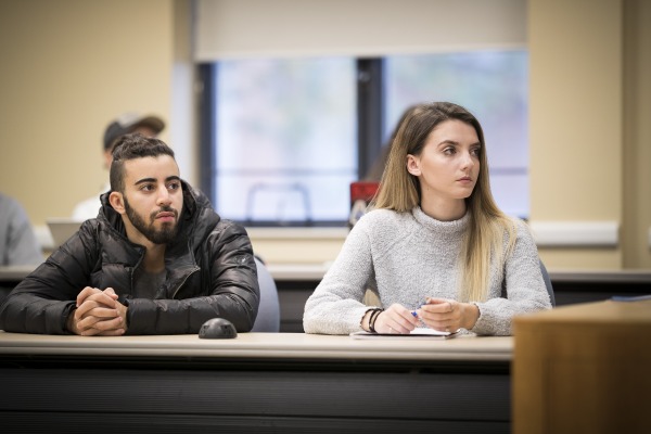 Two students at a conference table in a classroom