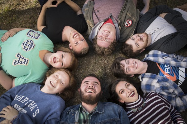 Students lay in a circle in the quad and laugh. 