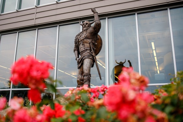 Viking statue with spring flowers beneath it