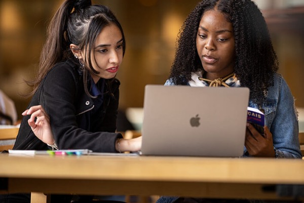 Two diverse female students studying in the library