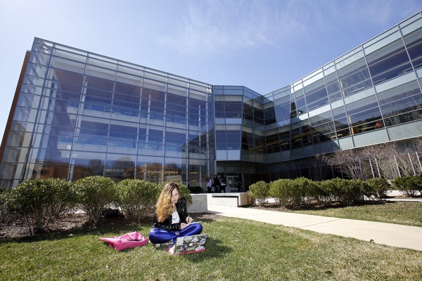 Student in front of the Berry library sitting in the grass reading