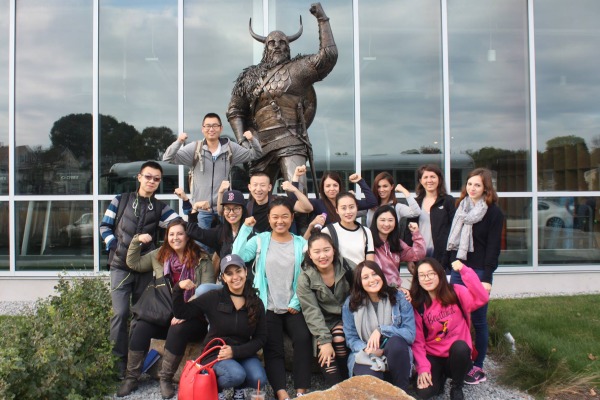 International students pose in front of the Viking statue