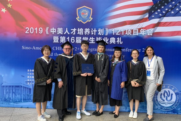 Chinese scholars at their graduation wit the Salem State provost