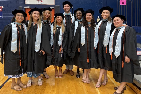 A group of graduate students in a cohort at commencement