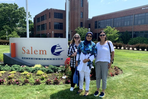 Saba Mahboubkhalajani and CIE staff in front of Salem State sign