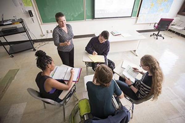 Students sit in a circle with their professor to discuss the French language. 