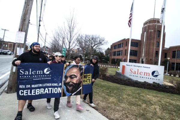 Students march on campus with a "Rev. Dr. Martin Luther King, Jr Celebration" sign
