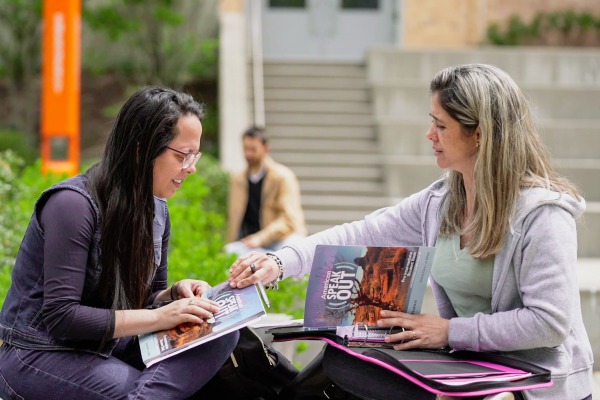 Two students talk outside at Salem State