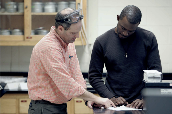 A professor and student at a science lab looking at an assignment