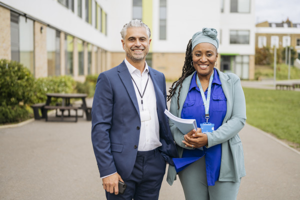 Two educational leaders standing in the forefront of a school