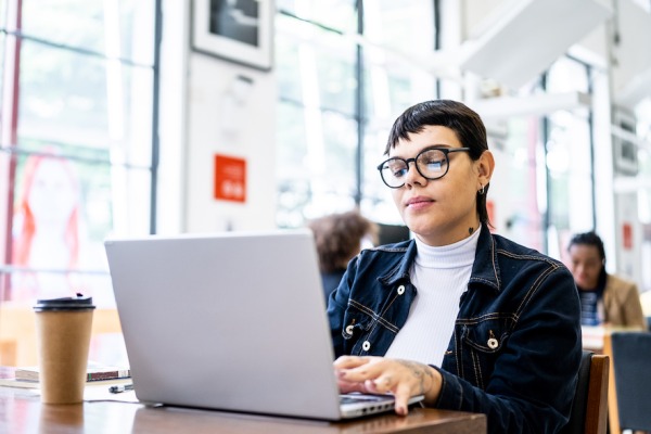 Person with coffee on computer