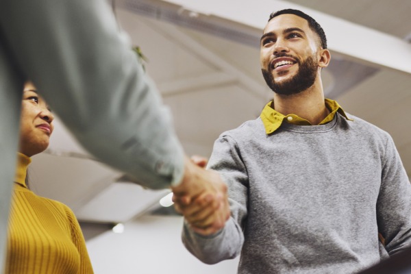 A young person shaking someone's hand