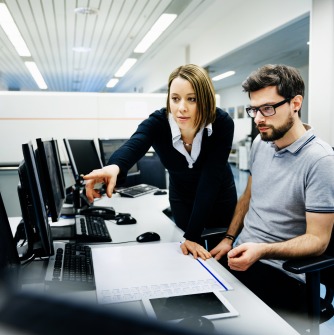 Two professionals at a computer desk